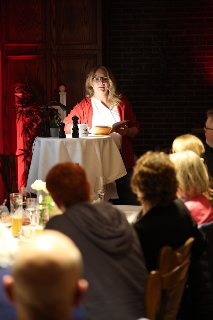 Premiere der Leseperformance "Serviert wird später" von Jana Rensle, Autorin vom Sammelband bei der Live- Lesung humorvoller Kurzgeschichten aus dem Gastronomie Alltag vor Publikum im Bümmersteder Krug in Oldenburg.